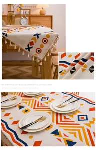 Primer plano de mantel de lino bohemio con patrones geométricos y borlas de flecos blancos