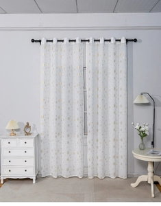 Detail showing white curtains with gold snowflake patterns and black grommet eyelets