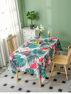 Detail of linen tablecloth featuring pink flamingo and green monstera leaf patterns