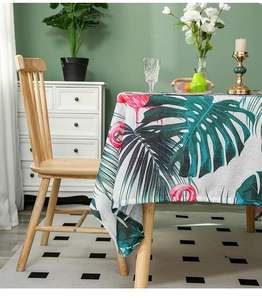 Detail of linen tablecloth featuring tropical monstera leaves and flamingo print