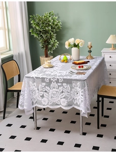 Detailed macro view of white floral lace tablecloth with elegant scalloped edges