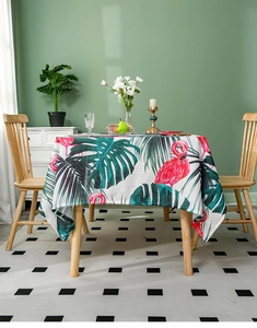Detailed texture of linen tablecloth featuring vibrant red flamingo and monstera leaf prints