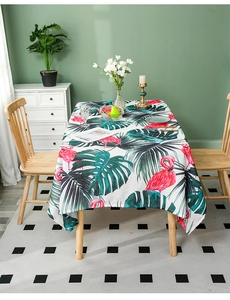 Detailed view of tropical tablecloth fabric with flamingo and monstera leaf prints