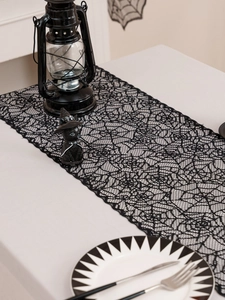 Detail showing black lace spiderweb table runner for Halloween festive home decor