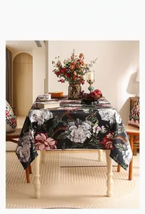 Détail d'une nappe en lin noir élégante avec grands motifs de pivoines roses et drapé fluide