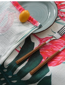 Detailed close-up of tropical monstera print on cotton linen tablecloth with fine stitching