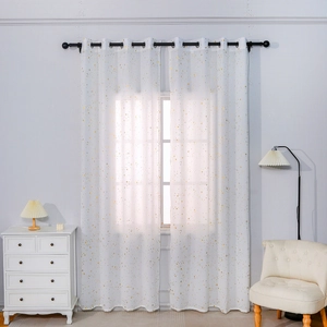 White sheer curtains with gold star patterns and grommet top in a modern living room