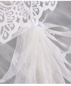 Macro shot of white lace sheer fabric featuring delicate hexagonal mesh and floral embroidery