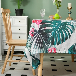 Linen table cloth with tropical monstera leaves and pink flamingo pattern in a dining room