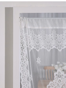 Detail of white lace curtain with floral embroidery and hexagonal mesh in European style