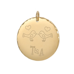 Macro detail of gold-plated bird heart engraved pendant with wavy edges for DIY jewelry