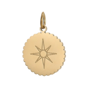 Close-up of golden vintage round scalloped pendant with engraved sunburst star pattern