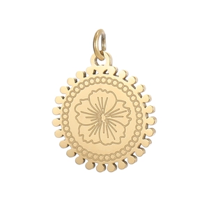 Close-up of vintage golden round pendant with floral engraving and beaded border texture