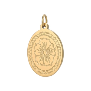 Macro shot of oval gold pendant with engraved floral pattern and beaded edge detail