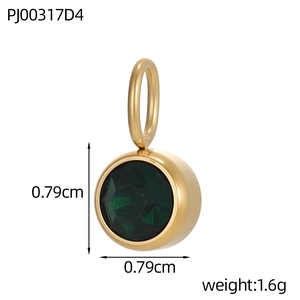 Macro detail of a 0.79cm gold stainless steel pendant with a dark green cubic zirconia