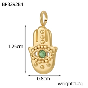 Detalle de un colgante mano de Fátima dorado con gema verde, tamaño 1,25 cm por 0,8 cm