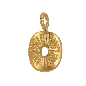 Détail macro du pendentif ovale en acier inoxydable doré avec des motifs rayonnants