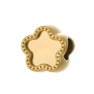 Détail du pendentif fleur dorée avec bordure perlée et centre à texture mate