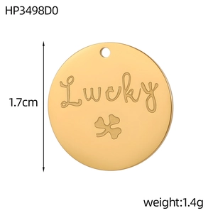 Close-up of golden lucky clover engraved stainless steel pendant, 1.7cm diameter