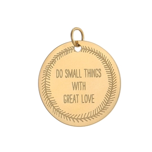 Macro view of golden stainless steel round pendant with engraved inspirational text