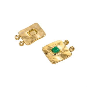 Close-up of gold-plated square pendants with hammer texture and green gemstone detail