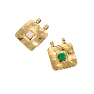 Detail of hammered gold fan-shaped pendants with inlaid colorful natural stones