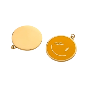 Detailed view of round metal pendant showing yellow enamel smiley face and gold back