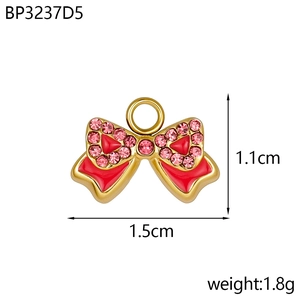 Détail du pendentif nœud doré avec émail rouge, cristaux roses et dimensions 1,5cm x 1,1cm