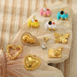 Collection of colorful enamel elephant pendants and golden heart charms on stone base
