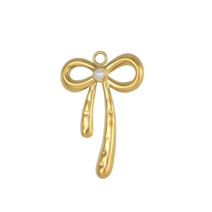 Macro detail of golden bow pendant featuring textured metal surface and central white pearl