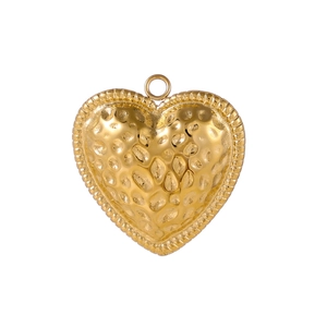 Macro detail of golden heart pendant with hammered texture and beaded edge finish