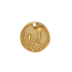 Detailed macro of a round gold floral pendant with intricate embossed plant patterns