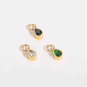 Detailed close-up of teardrop gemstone pendants in black, white, and green with gold plating