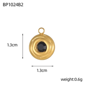 Macro detail of a 1.3cm vintage gold pendant with black stone and wavy metal texture