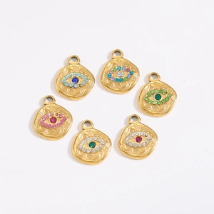Gros plan de pendentifs mauvais œil dorés avec cristaux colorés et texture ondulée