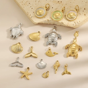 Ocean themed jewelry pendants with sea turtle and shell charms in gold and silver finishes