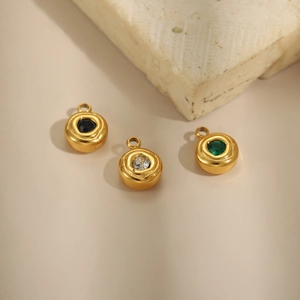 Macro detail of gold-plated fan charms with inlaid black, white and green gemstones