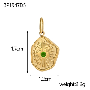 Detailed macro view of gold evil eye pendant with green stone and brushed metal texture