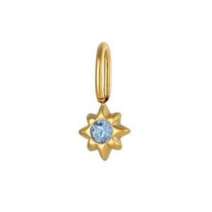 Macro detail of a gold starburst pendant with a light blue round gemstone insert