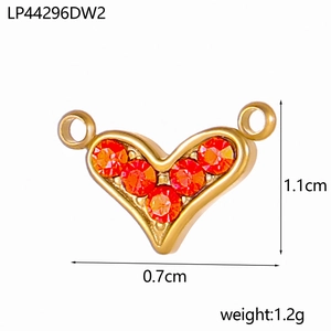 Detail eines Vintage-Herzanhängers mit fünf orangefarbenen Kristallen und Goldbasis