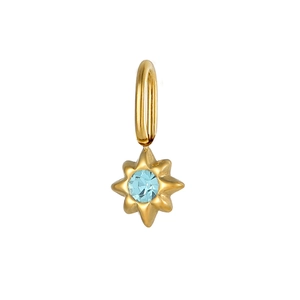 Macro detail of a gold eight-pointed star pendant with a sparkling light blue gemstone