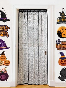 Detail of Halloween door curtain featuring lace spider webs and skull motifs in black and white