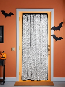 Lace Halloween door curtain with black palm prints on orange wall with pumpkins