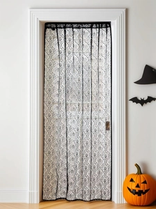 Detailed view of Halloween black lace curtain with ghost hand texture on a door