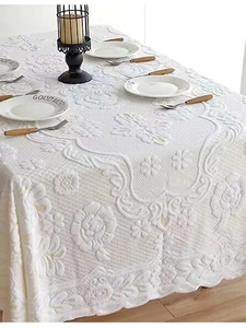 Detail shot of white European lace tablecloth with floral jacquard and scalloped edges