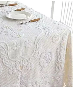 Macro detail of white floral jacquard lace tablecloth with elegant European textures