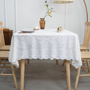 Elegant white lace tablecloth with embossed rose patterns and wavy scalloped edges