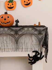 Detail of black lace fireplace mantel scarf with intricate bat patterns and fringe