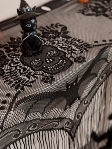 Detail of black lace Halloween curtain showing skull patterns and decorative tassels