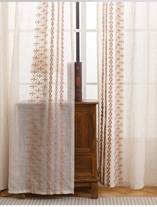 Detail van beige linnen transparant gordijn met bruin geometrisch ruitborduurwerk in kamer